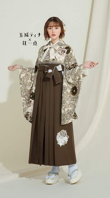 花柄のキャメル色の着物と茶色の袴を着たモデル