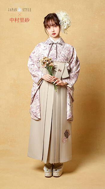 花柄のピンク色の着物とクリーム色の袴を着たモデル