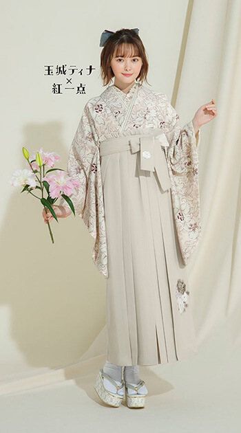 花柄のペールピンク色の着物とクリーム色の袴を着たモデル